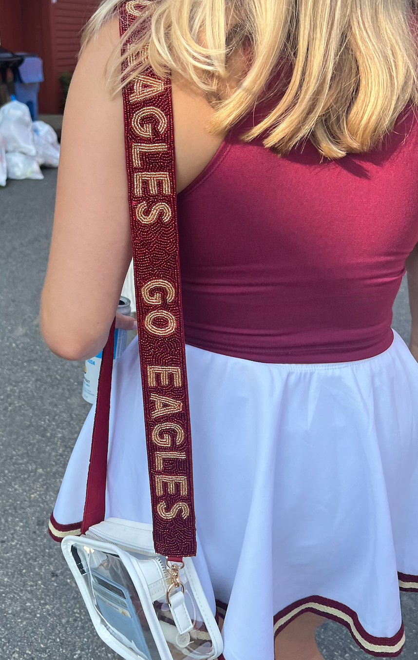 Person wearing Boston College beaded purse strap on clear stadium bag